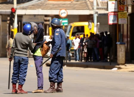 Riot police detain a protester during clashes after police banned planned protests over austerity and rising living costs called by the opposition Movement for Democratic Change (MDC) party in Harare