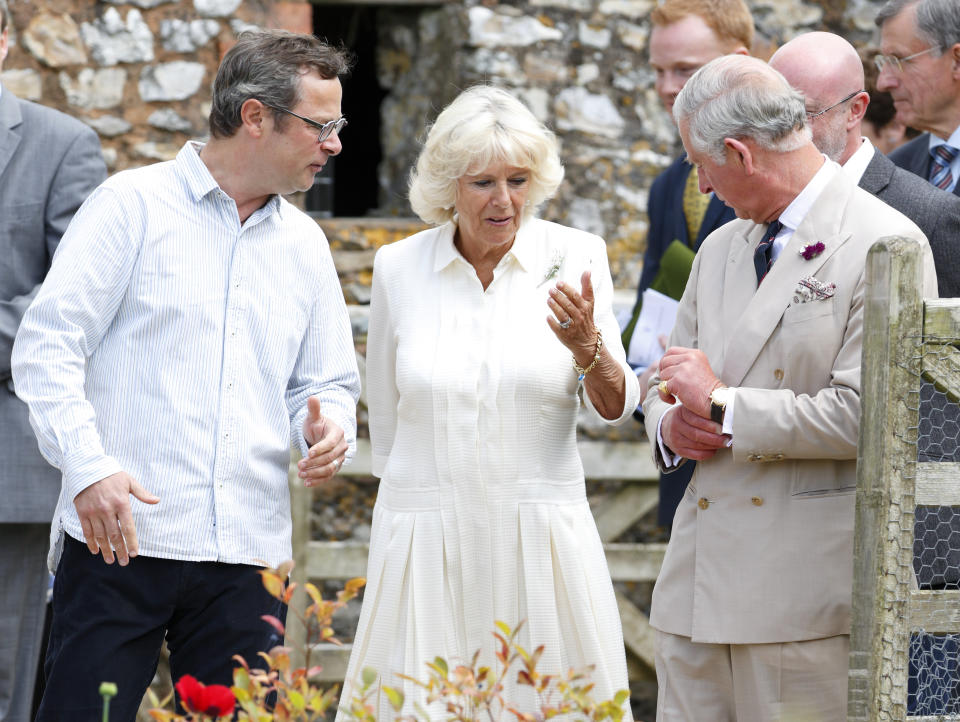 AXMINSTER, UNITED KINGDOM - JULY 15: (EMBARGOED FOR PUBLICATION IN UK NEWSPAPERS UNTIL 48 HOURS AFTER CREATE DATE AND TIME) Hugh Fearnley-Whittingstall looks on as Camilla, Duchess of Cornwall swats away an insect on Prince Charles, Prince of Wales's suit jacket as they tour the vegetable garden during a visit to River Cottage HQ, Musbury on July 15, 2014 in Axminster, England. (Photo by Max Mumby/Indigo/Getty Images)