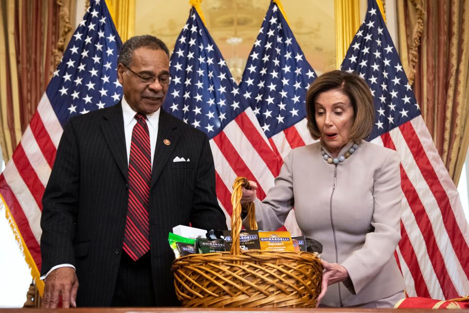 Pelosi offers a basket of Ghirardelli chocolate — a noted favorite — to Rep. Emanuel Cleaver of Missouri after losing a bet over the Super Bowl in 2020.