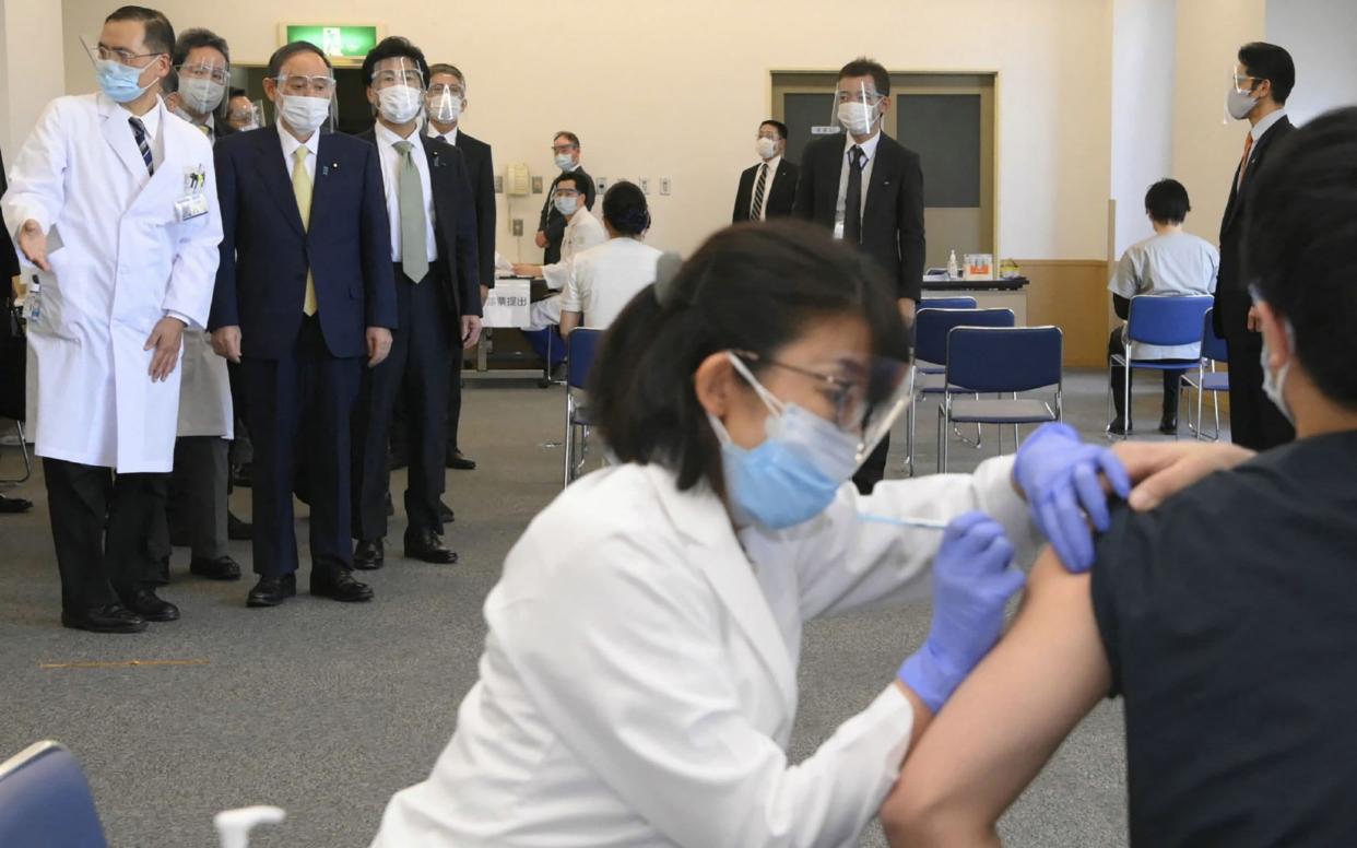 Japan's Prime Minister Yoshihide Suga (top, 2nd L) inspects the vaccination program against the Covid-19 coronavirus at the state-run Tokyo Medical Center in Tokyo - JAPAN POOL VIA JIJI PRESS /AFP