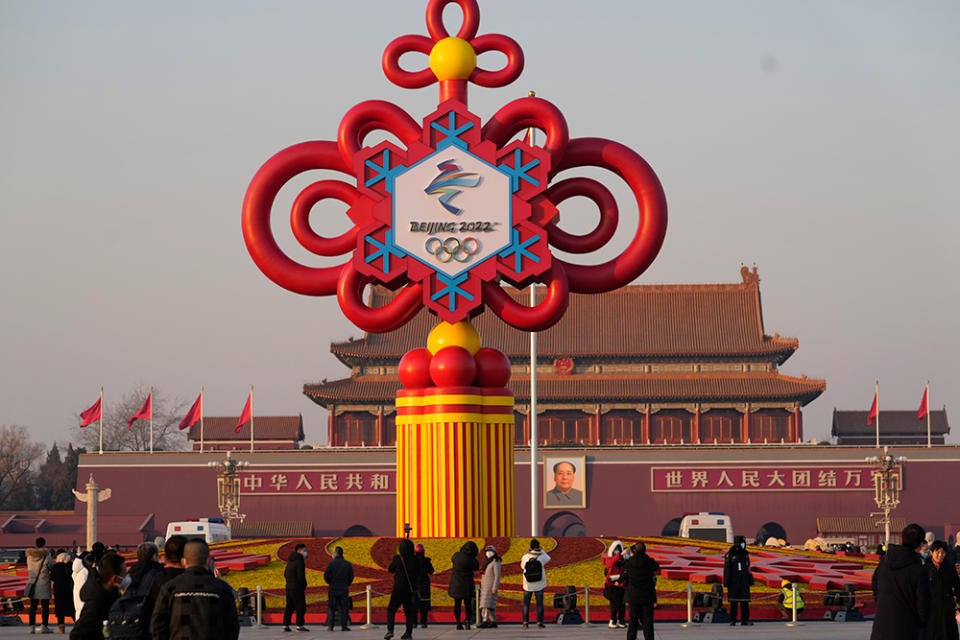 A Winter Olympics decoration rises over Tiananmen Square in Beijing. - Credit: AP