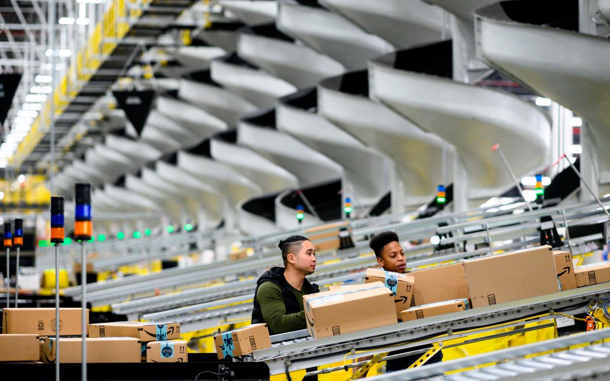 <p>Men work at a distribution station in the 855,000-square-foot Amazon fulfillment center in Staten Island, one of the five boroughs of New York City, on February 5, 2019</p> (JOHANNES EISELE/AFP via Getty Images)