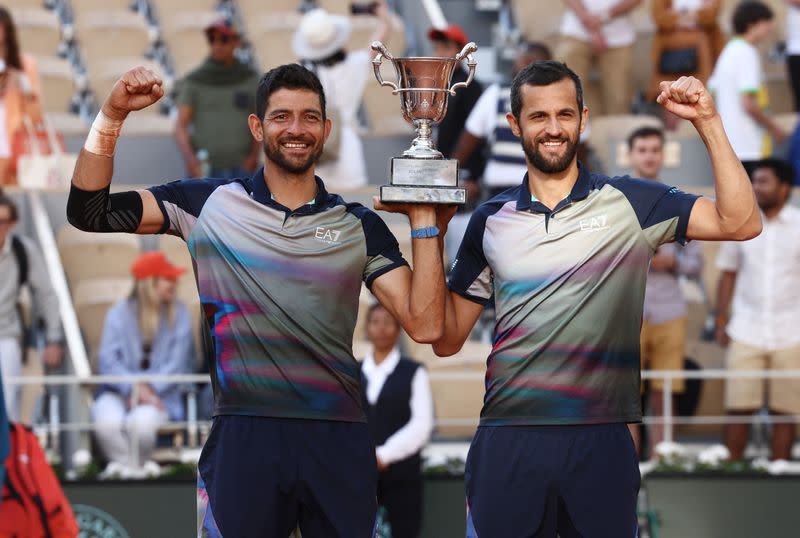 El salvadoreño Marcelo Arévalo y el croata Mate Pavic celebran su victoria en la final de dobles del Abierto de Francia contra los italianos Simone Bolelli y Andrea Vavassori, posando con el trofeo de campeones