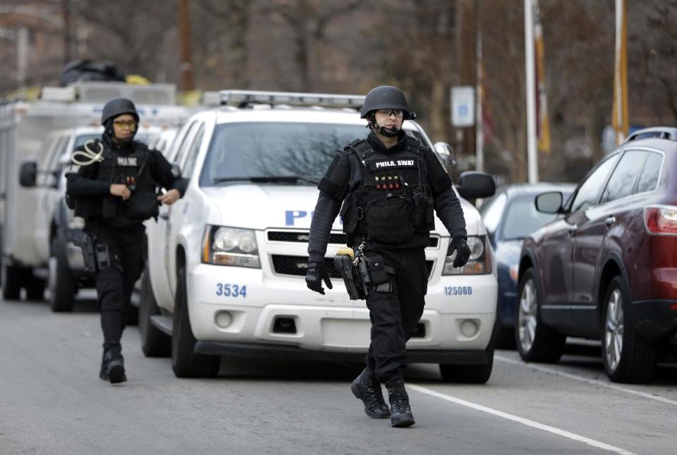 Police walk to the Delaware Valley Charter School Friday, Jan. 17, 2014, in Philadelphia. Police say two students have been shot at a Philadelphia high school. (AP Photo/Matt Rourke)