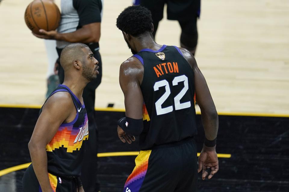 Phoenix Suns guard Chris Paul, left, talks with Suns center Deandre Ayton (22) during the first half of Game 1 of basketball's NBA Finals against the Milwaukee Bucks, Tuesday, July 6, 2021, in Phoenix. (AP Photo/Ross D. Franklin)