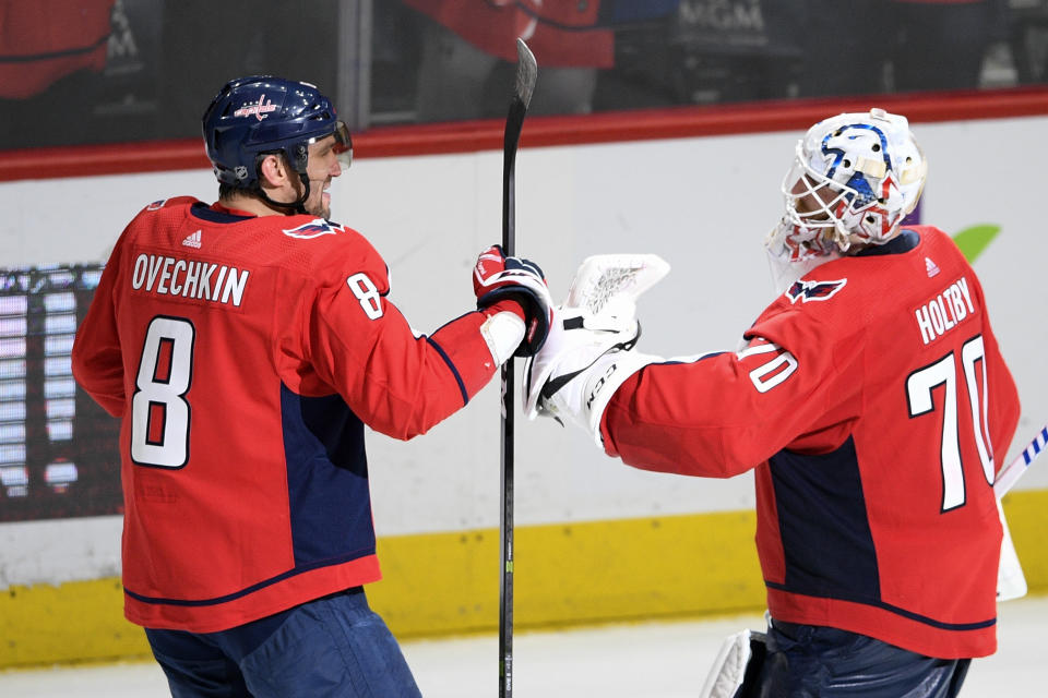 Washington Capitals left wing Alex Ovechkin (8), of Russia, and Washington Capitals goaltender Braden Holtby (70) celebrate after the team's NHL hockey game against the Winnipeg Jets, Tuesday, Feb. 25, 2020, in Washington. The Capitals won 4-3 in a shootout. (AP Photo/Nick Wass)