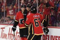 Mar 19, 2019; Calgary, Alberta, CAN; Calgary Flames left wing Matthew Tkachuk (19) celebrates with center Mikael Backlund (11) and right wing Michael Frolik (67) after scoring a empty net goal in the third period against the Columbus Blue Jackets at Scotiabank Saddledome. Flames won 4-2. Mandatory Credit: Candice Ward-USA TODAY Sports