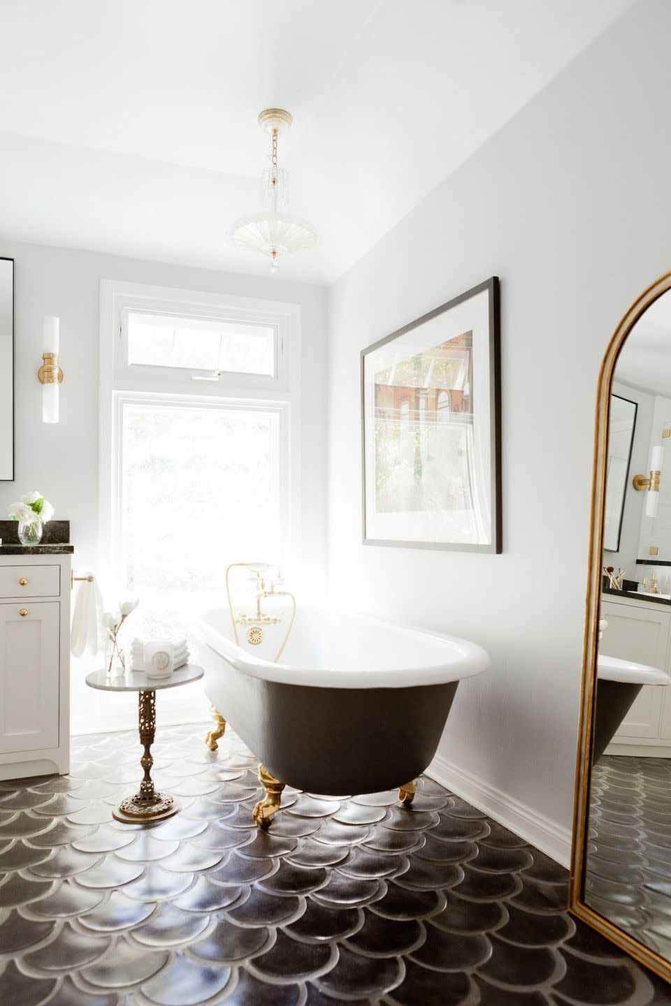 dark brown large scale fish tile bathroom floor, with clawfoot tub with exterior painted brown with gold feet, white walls