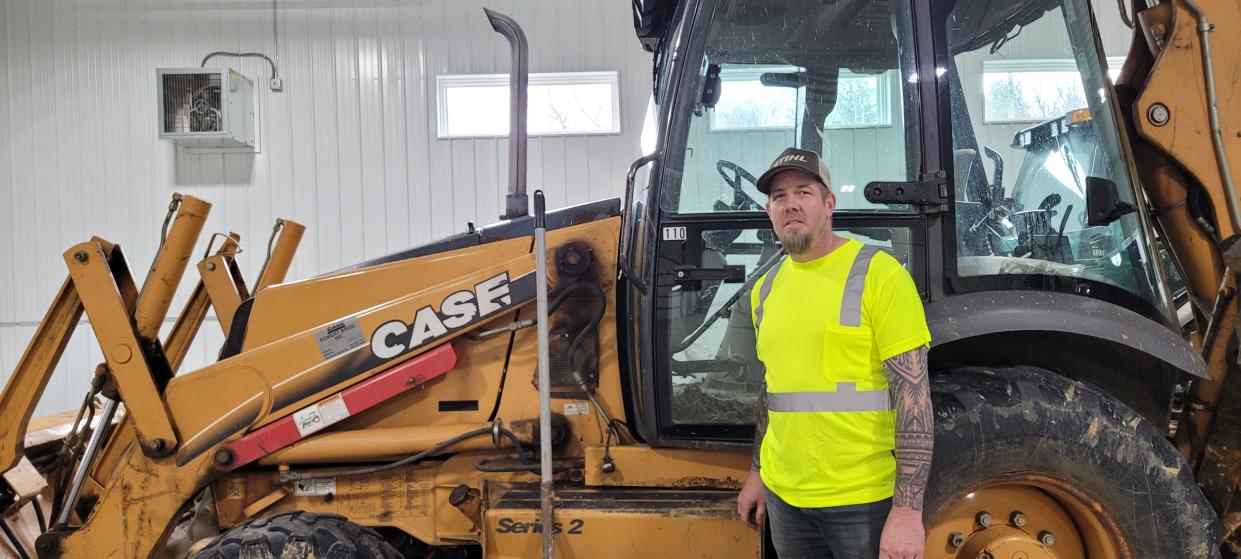 Loudonville Street Superintendent Jarrod Heffelfinger stands next to a backhoe in the maintenance department building. Heffelfinger said operating a backhoe was the only skill he hadn't mastered before joining the department nine years ago.