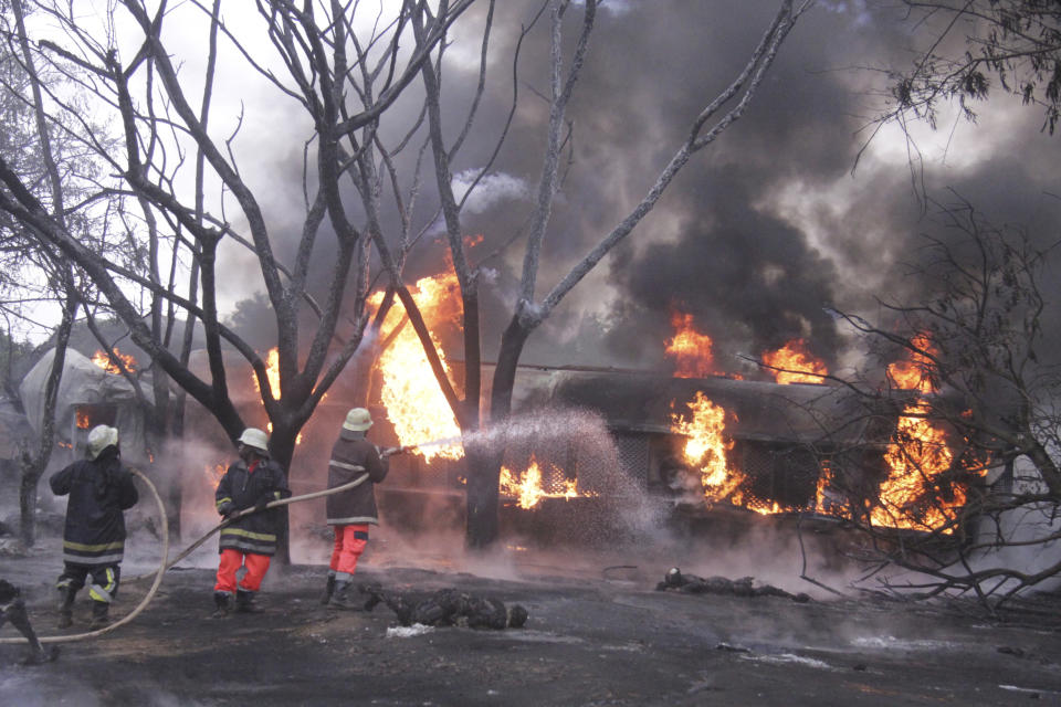 CORRECTING TO PETROL TANKER - Fire fighters try to extinguish a Petrol Tanker blaze, Saturday, Aug. 10 2019, in Morogoro, Tanzania.   A damaged tanker truck exploded in eastern Tanzania Saturday as people were trying to siphon fuel out of it, killing at least 62, in one of the worst incidents of its kind in the East African country.  (AP Photo)