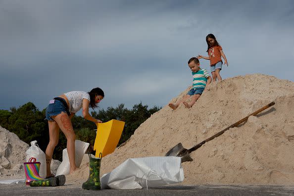 PINELLAS PARK, FLORIDA - AUGUST 29: Loemys Rivera-Valentin and her children D'Angelo Gabriel Abreu-Suarez (C) and Zaelys Loemys Robles-Rivera fill sandbags at the Helen S. Howarth Community Park ahead of the possible arrival of Hurricane Idalia on August 29, 2023 in Pinellas Park, Florida. Hurricane Idalia is forecast to make landfall on the Gulf Coast of Florida on Wednesday morning. (Photo by Joe Raedle/Getty Images)