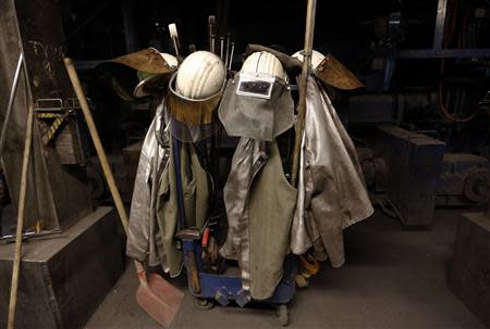 Protective coats and helmets are seen at a casting roller at ThyssenKrupp Steel Europe AG in Duisburg November 29, 2013. REUTERS/Ina Fassbender