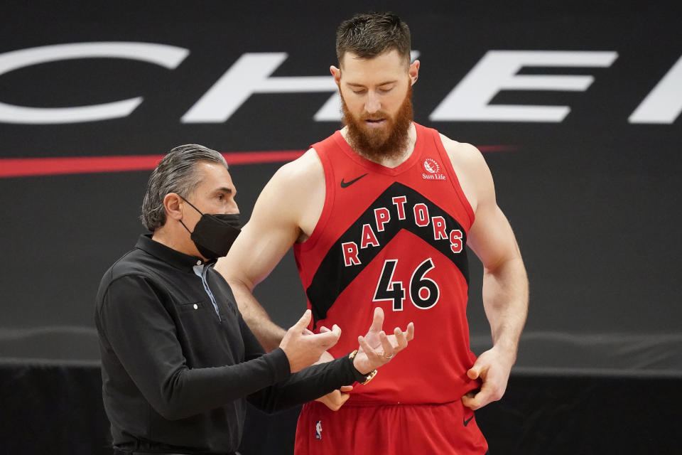 Toronto Raptors assistant coach Sergio Scariolo talks to center Aron Baynes (46) during the first half of an NBA basketball game against the Houston Rockets Friday, Feb. 26, 2021, in Tampa, Fla. Scariolo is filling in for head coach Nick Nurse, who is under coronavirus protocol. (AP Photo/Chris O'Meara)
