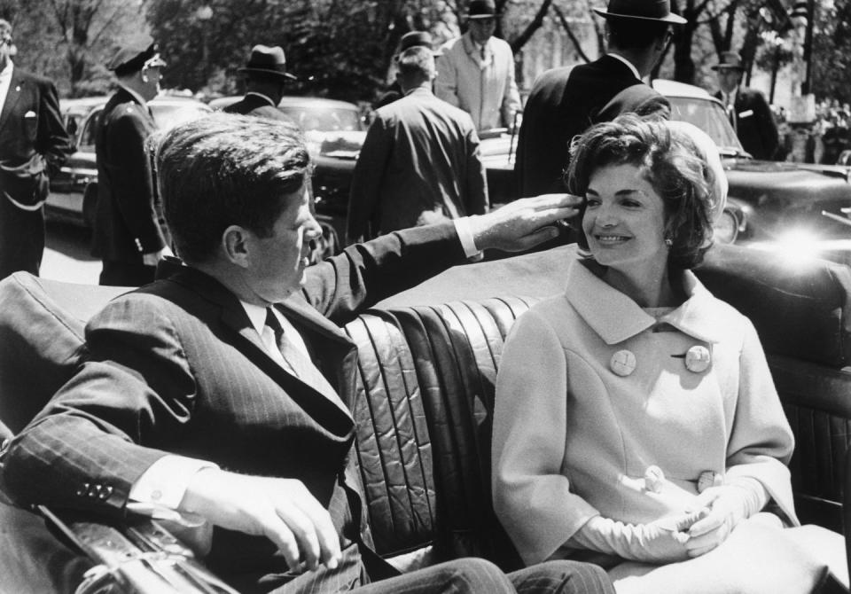 <p>President John F. Kennedy fixes his wife Jackie's wind-blown hair as they ride in a convertible between Blair House and the White House. They had just met President Habib Ben Ali Bourguiba of Tunisia and his wife. Bourguiba is in Washington for talks with government leaders. </p>