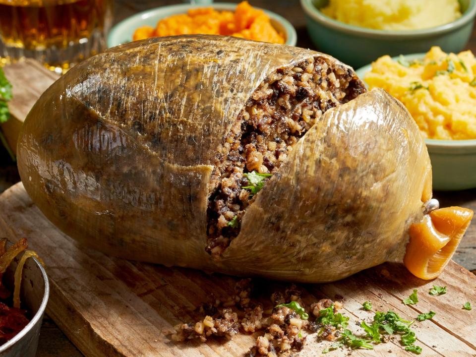 haggis served on a cutting board with a potato