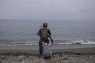 A man is assisted by a soldier of the Spanish Army near the border of Morocco and Spain, at the Spanish enclave of Ceuta, on Tuesday, May 18, 2021. Ceuta, a Spanish city of 85,000 in northern Africa, faces a humanitarian crisis after thousands of Moroccans took advantage of relaxed border control in their country to swim or paddle in inflatable boats into European soil. (AP Photo/Bernat Armangue)