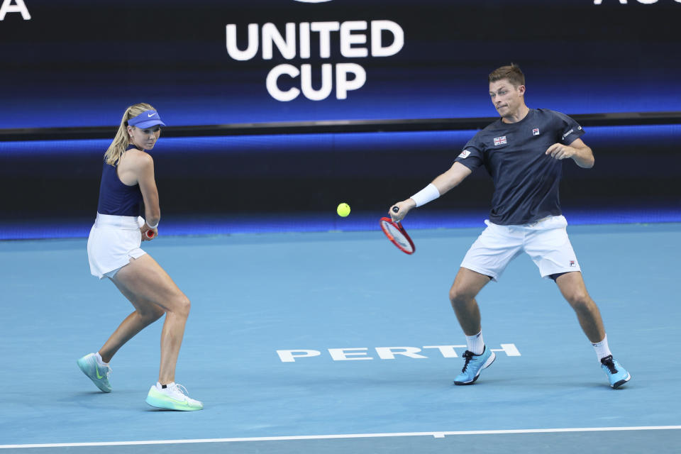 Cameron Norrie of Britain hits a return as partner Katie Boulter looks on during their match against Taylor Fritz and Jessica Pegula of the United States at the United Cup tennis tournament in Perth, Australia, Sunday, Dec. 31, 2023. (AP Photo/Trevor Collens)