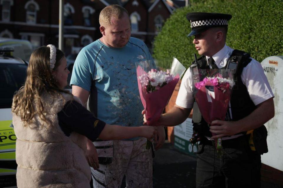 Una mujer entrega flores por las víctimas