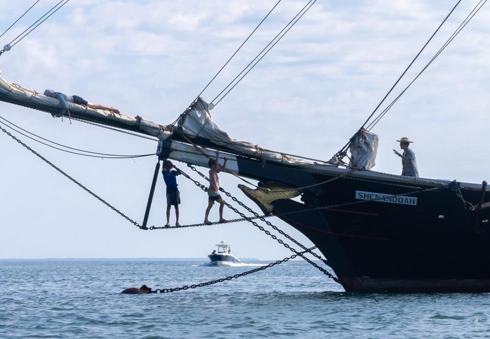 Sam Shields, right, a captain in training, walks over to youths who are working at the tip of the Shenandoah tall ship in Vineyard Haven.
