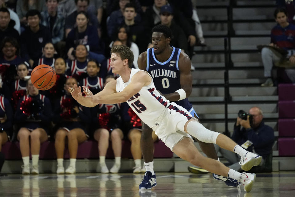 Pennsylvania's Andrew Laczkowski, left, passes against Villanova's TJ Bamba during the first half of an NCAA college basketball game, Monday, Nov. 13, 2023, in Philadelphia. (AP Photo/Matt Slocum)