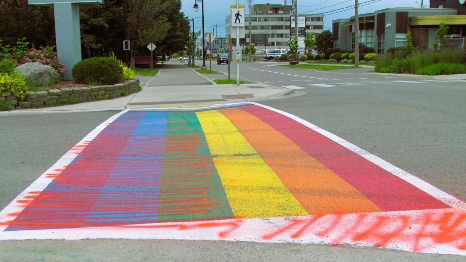 The recently painted rainbow flag at the intersection of Spring at Bay Street is pictured vandalized with red spray paint Tuesday evening. This crosswalk, painted by city workers in late June for Pride Month, replaced the previous Pride crosswalk near the James L. McIntyre Centennial Library. The intersection was the scene of weekend protests and counter-protests, featuring self-described Evangelical Christians and members of the local LGBTQ+ community.