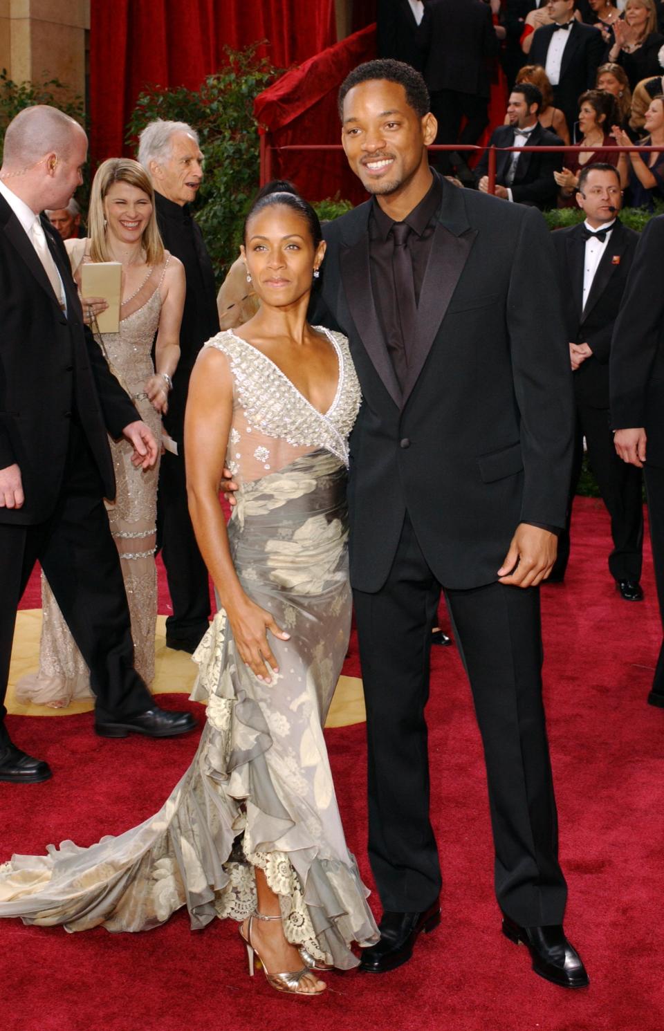 A young Jada Pinkett Smith in Valentino with Will Smith in a black tuxedo at the Oscars. 