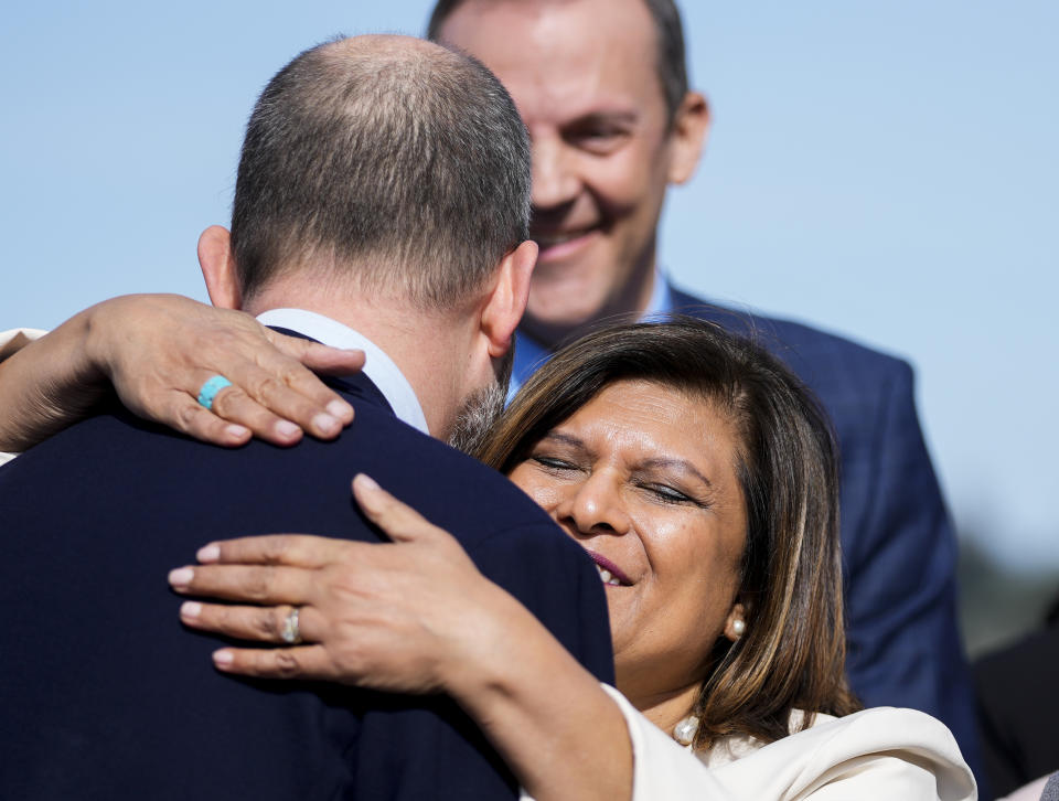 State Rep. Drew Hansen, D-Bainbridge Island, left, the primary sponsor of House Bill 1469, is hugged by Rep. Vandana Slatter, D-Bellevue, after Washington Gov. Jay Inslee signed the bill, which shields abortion and gender-affirming care patients and providers from prosecution by out-of-state authorities and prevents cooperation with investigations, Thursday, April 27, 2023, at the University of Washington's Hans Rosling Center for Population Health in Seattle. (AP Photo/Lindsey Wasson)