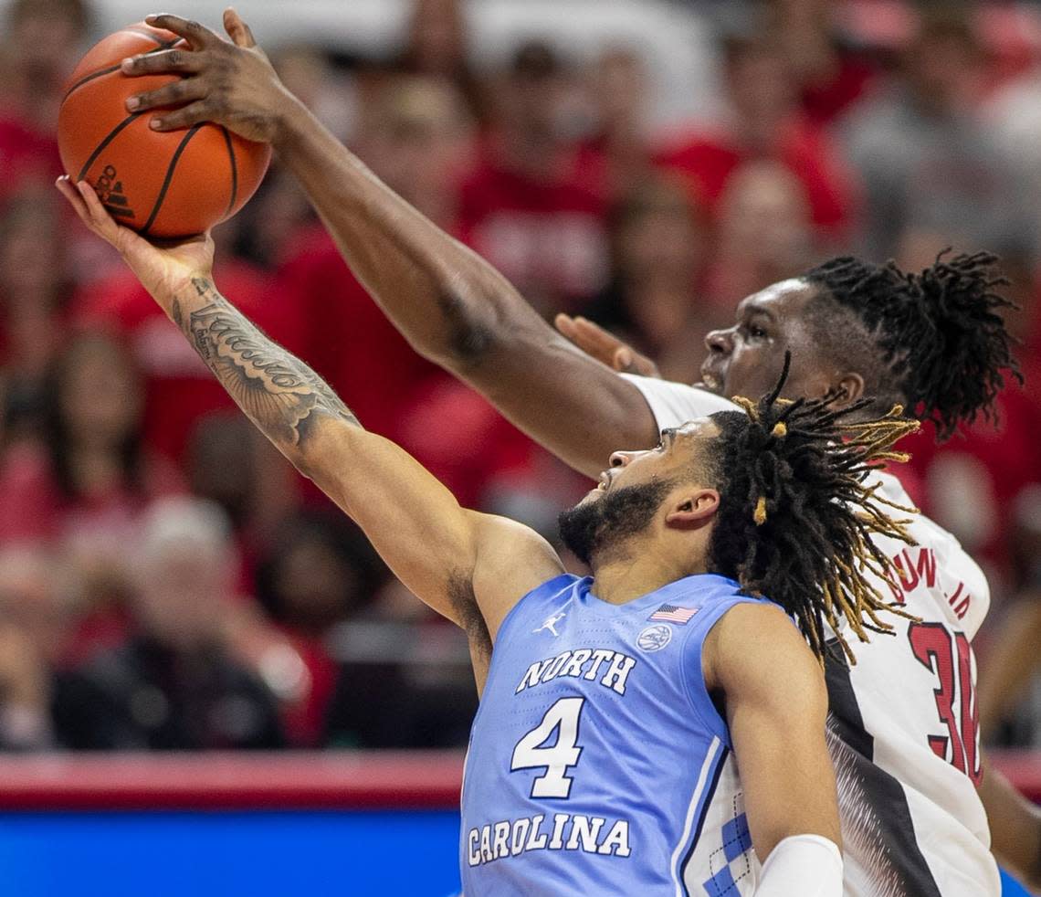 N.C. State’s D.J. Burns (30) blocks a shot by North Carolina’s R.J. Davis (4) during the second half on Sunday, February 19, 2023 at PNC Arena in Raleigh, N.C.