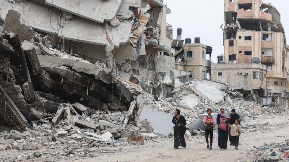 PHOTO: Palestinian women and children walk past the ruins of buildings destroyed by earlier Israeli bombardment in Gaza City on April 8, 2024, amid the ongoing conflict between Israel and the Palestinian Hamas militant group. (AFP via Getty Images)