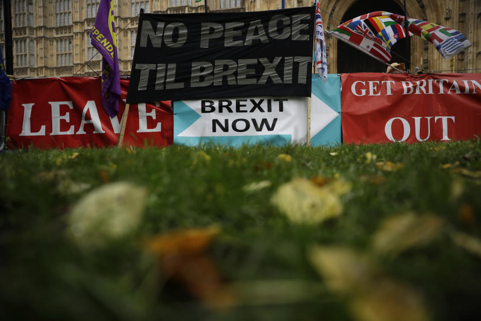 Banners placed by pro-Brexit leave the European Union supporters stand displayed backdropped by the Houses of Parliament in London, Thursday, Oct. 24, 2019. Britain's Prime Minister Boris Johnson won Parliament's backing for his exit deal on Wednesday, but then lost a key vote on its timing, effectively guaranteeing that Brexit won't happen on the scheduled date of Oct. 31.  (AP Photo/Matt Dunham)