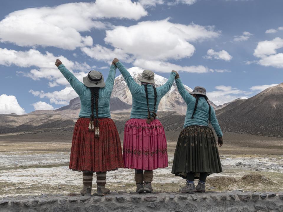 Aymara indigenous women raise their hands