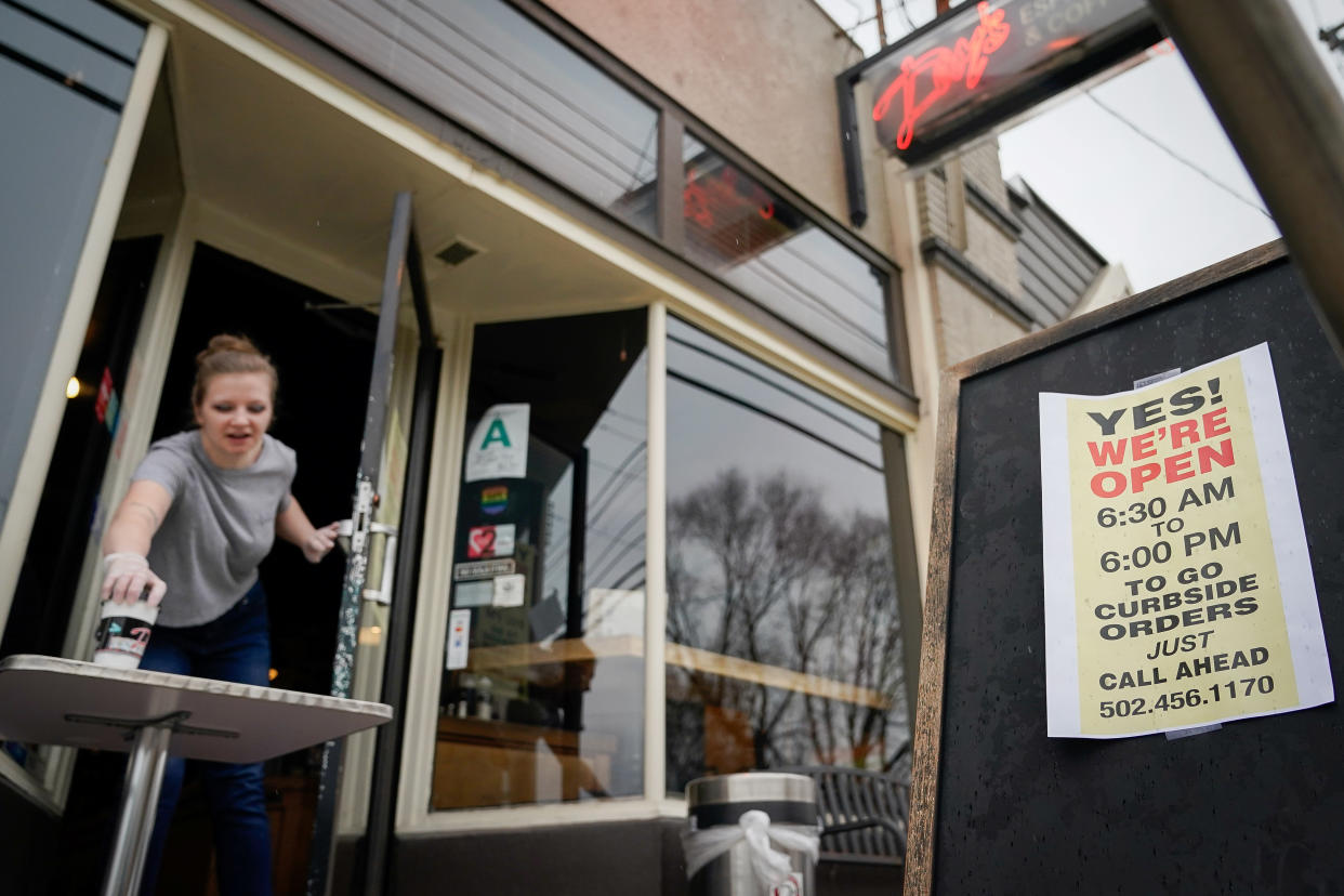 Kayla Marx places an order outside the door of Day's Espresso and Coffee Shop after a state mandated carry-out only policy went into effect in order to slow the spread of the novel coronavirus (COVID-19) in Louisville, Ky, U.S. March 24, 2020. REUTERS/Bryan Woolston