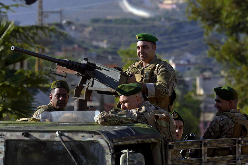 Lebanese army soldiers sit on their armored vehicle as they patrol the Lebanese side of the Lebanese-Israeli border in the southern village of Kfar Kila, Lebanon, Friday, Oct. 13, 2023. Sporadic acts of violence have been reported over the past days along the tense Lebanon-Israel border. (AP Photo/Bilal Hussein)