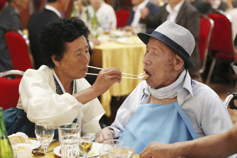 North Korean Ahn Jong Sun, 70, left, feeds her South Korean father Ahn Jong-ho, 100, during a dinner at the Diamond Mountain resort in North Korea, Monday, Aug. 20, 2018. Dozens of elderly South Koreans crossed the heavily fortified border into North Korea on Monday for heart-wrenching meetings with relatives most haven't seen since they were separated by the turmoil of the Korean War. (Lee Ji-eun/Yonhap via AP)