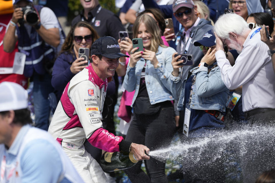 Kyle Kirkwood sprays his crew members after winning the IndyCar Grand Prix of Long Beach auto race Sunday, April 16, 2023, in Long Beach, Calif. (AP Photo/Jae C. Hong)