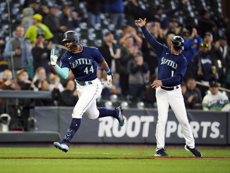 Seattle Mariners' Julio Rodriguez celebrates with third base coach Manny Acta after hitting a two-run home run against the Milwaukee Brewers during the third inning of a baseball game Wednesday, April 19, 2023, in Seattle. (AP Photo/Lindsey Wasson)