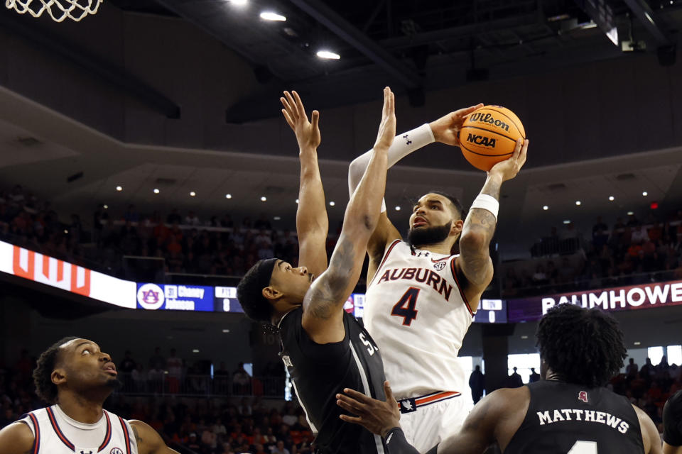 Auburn forward Johni Broome (4) is fouled by Mississippi State forward Tolu Smith, center left, as he goes up for a shot during the second half of an NCAA college basketball game, Saturday, March 2, 2024, in Auburn, Ala. (AP Photo/ Butch Dill)