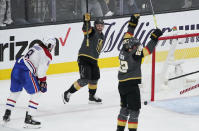 Vegas Golden Knights center Jonathan Marchessault, center, celebrates after Vegas Golden Knights defenseman Nick Holden, right, scored against the Montreal Canadiens during the third period in Game 1 of an NHL hockey Stanley Cup semifinal playoff series Monday, June 14, 2021, in Las Vegas. (AP Photo/John Locher)