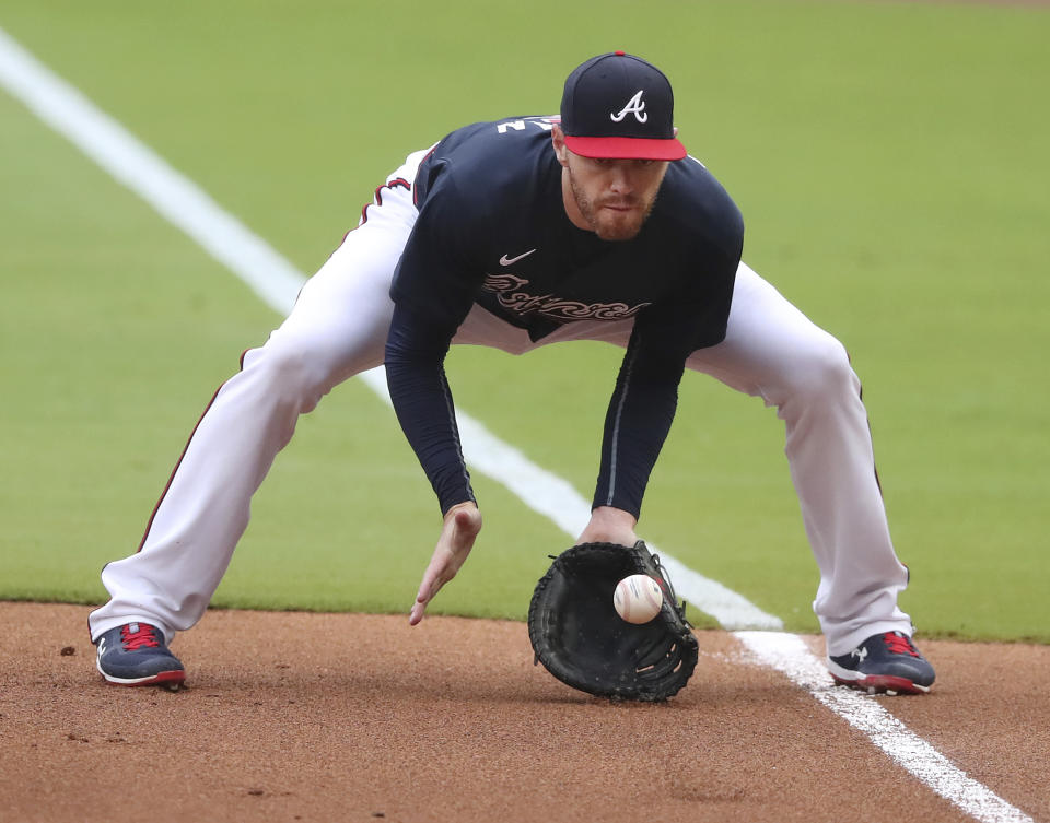 Atlanta Braves first baseman Freddie Freeman fields a ground ball by Yonder Alonso and tags first for the out during the second inning of an intrasquad game Saturday, July 18, 2020, in Atlanta. It was Freeman's fist game since his battle with Covid-19. (Curtis Compton/Atlanta Journal-Constitution via AP)