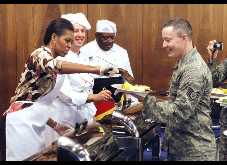 The first lady of the United States Michelle Obama, left, serves food for US soldiers and their relatives at Ramstein Airbase in Ramstein, Germany, Thursday, Nov. 11, 2010. Michelle Obama makes a series of stops within the Kaiserslautern Military Community on Veterans Day to thank US servicemen and women for their work. (AP Photo/Michael Probst)