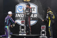 Will Power, center, of Australia, Romain Grosjean, left, of Switzerland, and Colton Herta celebrate on the victory podium following an IndyCar auto race at Indianapolis Motor Speedway, Saturday, Aug. 14, 2021, in Indianapolis. Power won the race, Grosjean finished second and Herta finished third. (AP Photo/Darron Cummings)