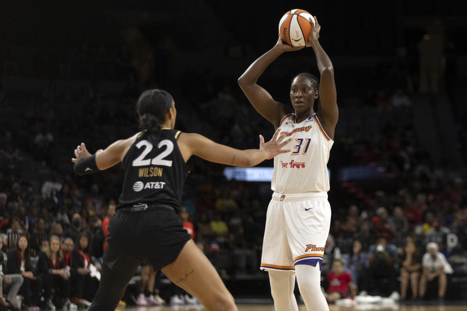 Phoenix Mercury center Tina Charles (31) looks to pass while Las Vegas Aces forward A'ja Wilson (22) guards during the second half of a WNBA basketball game, Saturday, May 21, 2022, in Las Vegas. (AP Photo/Ellen Schmidt)