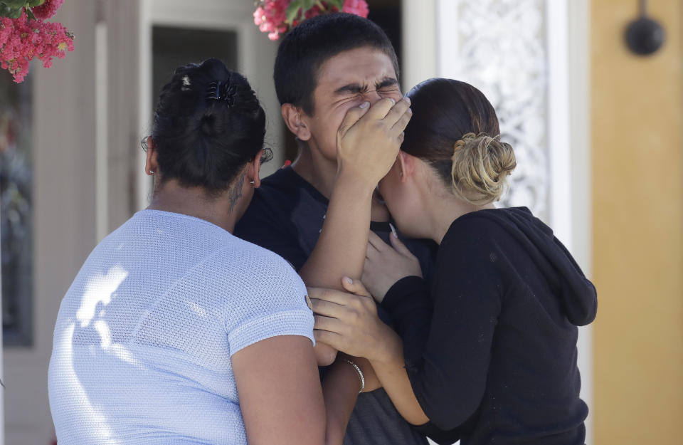 Joshua Guicho, 16, center, cries between his aunts Josephine Guicho, left, and Erica Guicho while being interviewed about the shooting death of his 6-year-old cousin Stephen Romero in San Jose, Calif., Monday, July 29, 2019. Romero is one of three young people who died when a gunman opened fire at a popular California food festival Sunday. (AP Photo/Jeff Chiu)