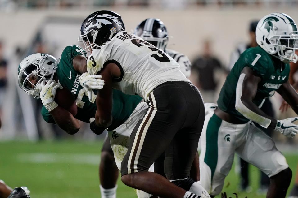 Michigan State running back Jarek Broussard is tackled by Western Michigan linebacker Zaire Barnes (3) during the second half of an NCAA college football game, Friday, Sept. 2, 2022, in East Lansing, Mich.