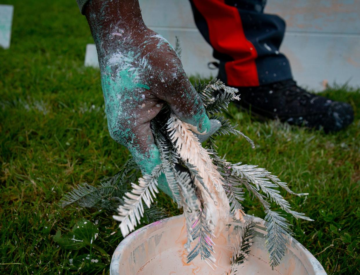 Artist Shawn Goddard, of the BIPOC Art Collective, dips greenery into paint and uses it to create an art piece during the 2022 Eugene Juneteenth Celebration.