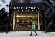 A woman walks past a Burberry shop in Beijing, July 11, 2012.