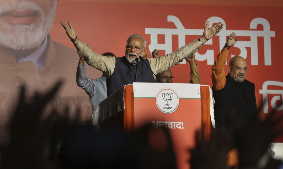 Indian Prime Minister Narendra Modi addresses party supporters, standing next to his Bharatiya Janata Party (BJP) President Amit Shah at their headquarters in New Delhi, India, Thursday, May 23, 2019. Modi's Hindu nationalist party claimed it won reelection with a commanding lead in Thursday's vote count, while the head of the main opposition party conceded a personal defeat that signaled the end of an era for modern India's main political dynasty. (AP Photo/Manish Swarup)