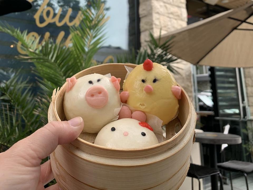 hand holding basket of character buns outside of  Harumama Noodles + Buns in san diego