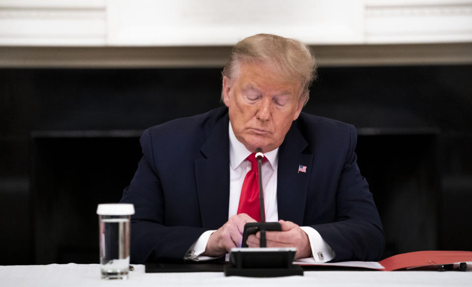 El entonces presidente Donald Trump escribe en su teléfono durante una mesa redonda con gobernadores en la Casa Blanca en Washington, el 18 de junio de 2020. (Doug Mills/The New York Times)