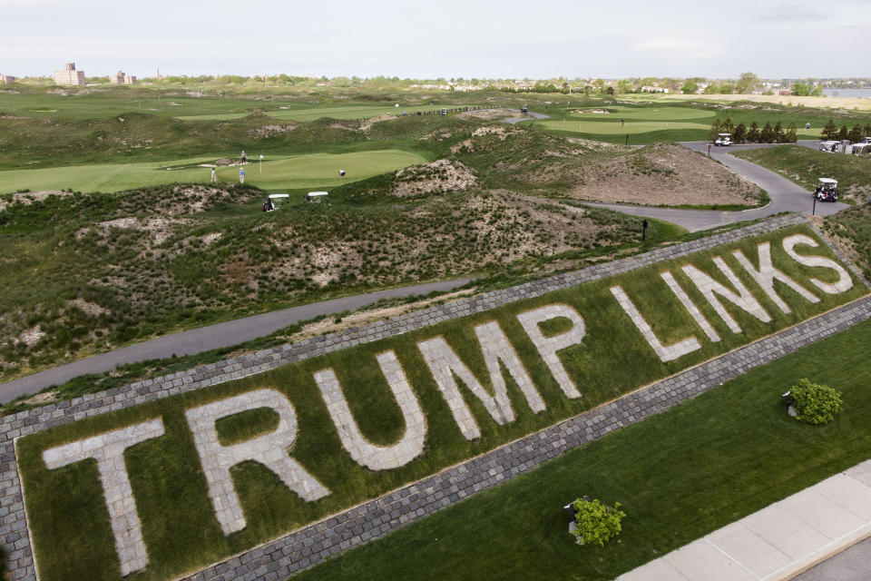 Image: Patrons play the links as a giant branding sign is displayed with flagstones at Trump Golf Links at Ferry Point in the Bronx borough of New York (John Minchillo / AP file)